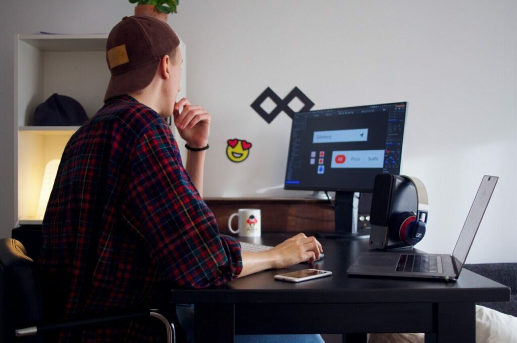 Man wearing a cap working on the computer