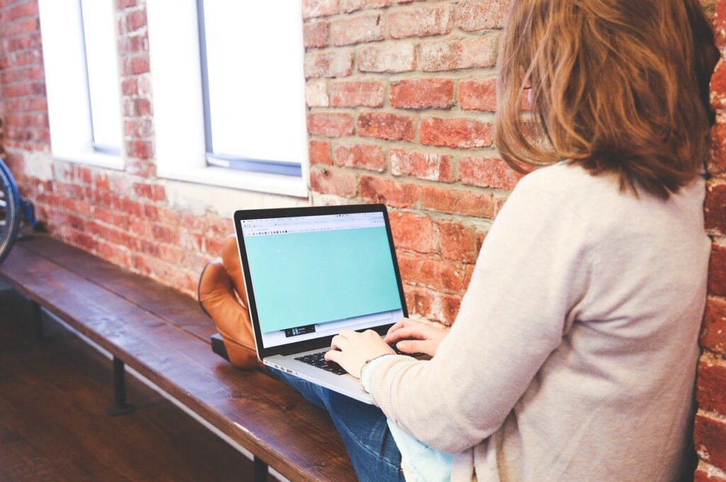 Woman sitting on a bench using a laptop